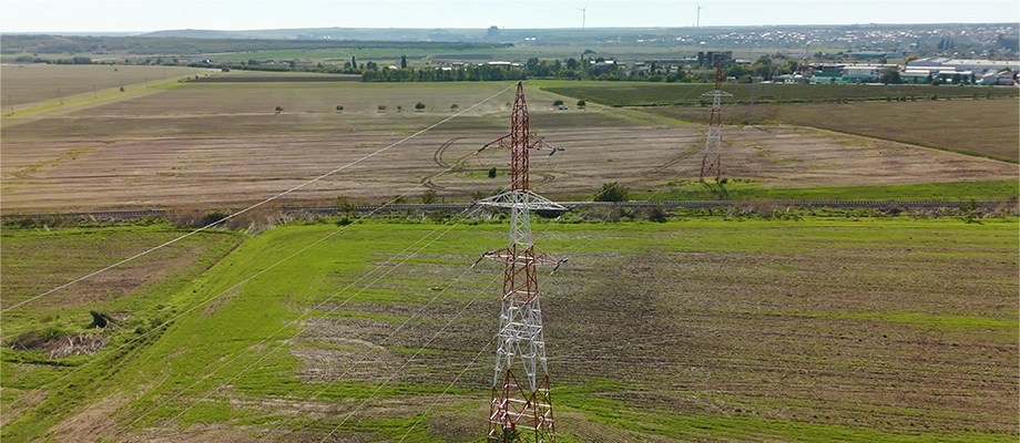 Stalp de inalta tensiune in peisaj rural, parte din infrastructura Retele Electrice, asigurand transportul eficient al energiei catre comunitati si industrii