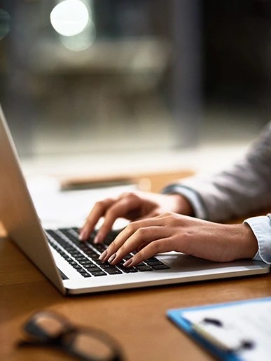 Persoana tastand pe un laptop, gestionand date despre reteaua electrica.