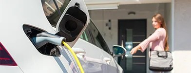 Masina electrica in curs de incarcare acasa, simbol al eficientei energetice si mobilitatii sustenabile